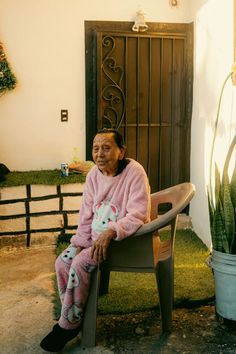 an old woman sitting in a chair with a stuffed animal