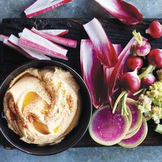 an assortment of vegetables including radishes, celery, and hummus