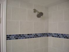 a shower head with blue and white tiles on it