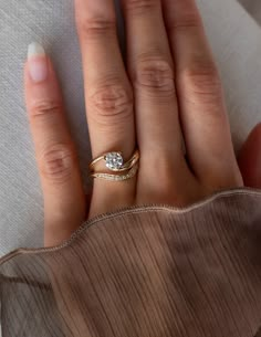 a woman's hand with a diamond ring on top of her left hand and the other half of her right hand