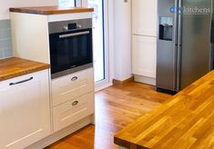 a kitchen with an oven, refrigerator and wooden counter tops