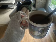 a woman holding a cup of coffee in her hand