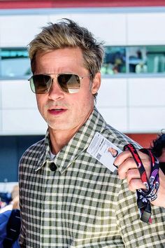 a man with sunglasses and a name tag in his hand