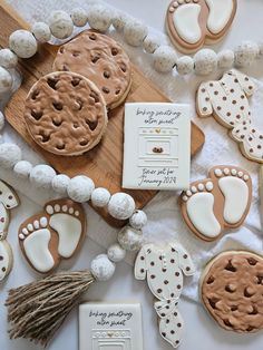 some cookies are laying on a table with white frosting and brown decorations around them