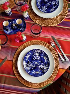 the table is set with blue and white plates, silverware, and utensils