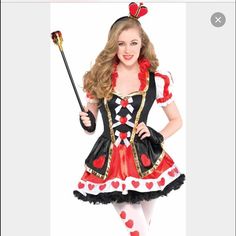 a woman in a red and black costume is holding a wand with hearts on it