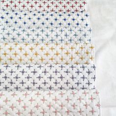 four different colored crosses on white fabric