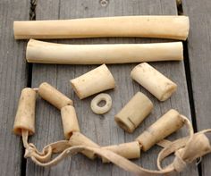 several pieces of ivory are laid out on a wooden surface, including one tube and two tubes