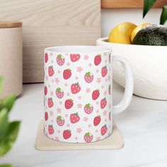 a white mug with strawberries and flowers on it