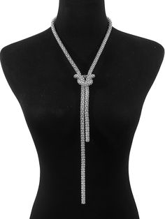 a black mannequin with a silver necklace on it's neck and a bow tie