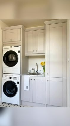 an appliance is displayed in the kitchen with white cabinets and washer and dryer