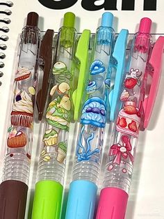 four pens are lined up next to each other with cartoon images on the inside of them