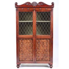 an antique wooden cabinet with glass doors and carvings on the front, sitting against a white background