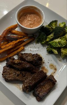 a white plate topped with steak, fries and broccoli