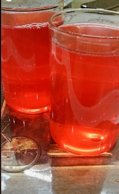 two glasses filled with liquid sitting on top of a table