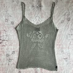 a crocheted tank top is laying on a bed