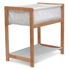 a wooden baby crib with a white sheet on the top and bottom shelf below it