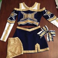 a cheerleader uniform is displayed on a wooden floor with other items around the room