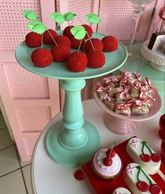 there are many cupcakes on the table with strawberries and candy canes