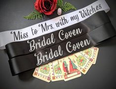 a bride's sash with cards and flowers on it, next to a rose