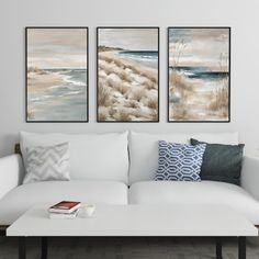 a living room with three paintings on the wall