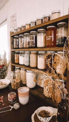 the shelves are filled with many different types of food and drink in glass jars on them