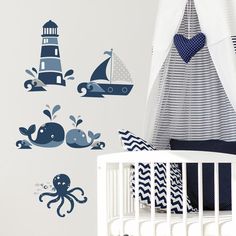 a baby's room decorated in blue and white with an octopus, whale, lighthouse and ship wall decals