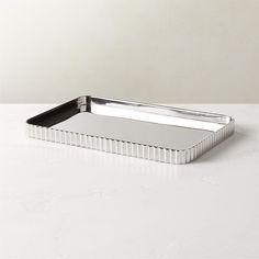 a rectangular metal tray on a white table