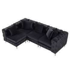 a black sectional sofa with pillows on it's back and legs, facing the camera