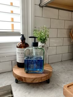 a soap dispenser sitting on top of a wooden tray