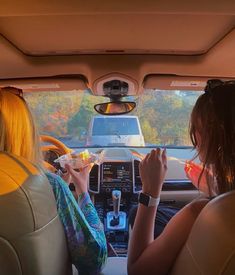 two women sitting in the back seat of a car