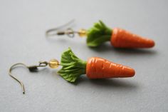 two tiny carrots are dangling from earrings