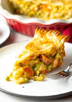 a piece of quiche on a plate with a fork in front of the pie