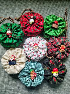 six fabric hair scrunffs in various colors and patterns on a gray surface with christmas decorations around them