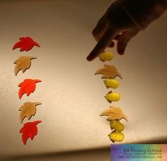 a hand reaching for leaves on a string