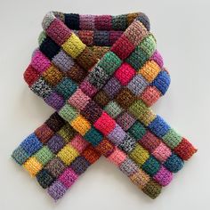 multicolored knitted scarfs laid out on top of each other