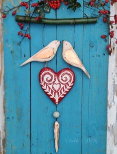 two birds are perched on top of a heart shaped decoration in front of a blue door