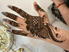 a woman's hand with hennap on it, and the hands are decorated with intricate designs