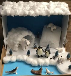 an open cardboard box filled with fake animals and snow