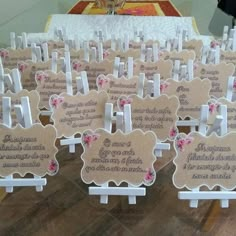 there are many wooden signs on display in front of a table with white chairs and pink flowers