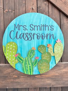 a wooden sign that says mrs smith's classroom with two cactuses on it