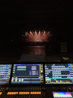 there are many lights on the stage in the dark room with sound boards and microphones