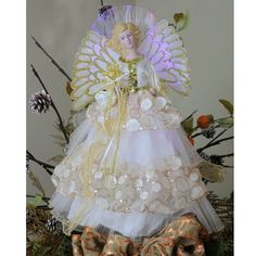 a white angel figurine sitting on top of a pile of bows and ribbons