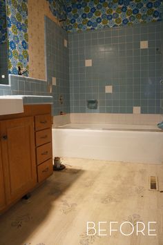 the bathroom is being remodeled with blue tile on the walls and wood flooring around the tub