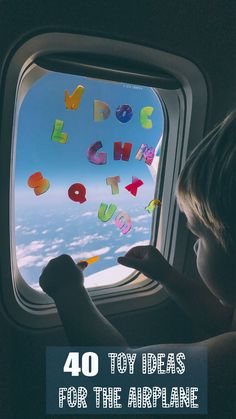 a child looking out an airplane window at the sky and clouds with letters written on it