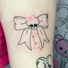 a woman's arm with a skull and bow tattoo on it