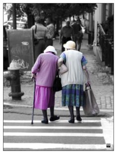 two elderly women walking across a cross walk