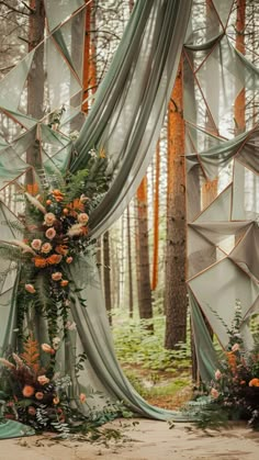 an outdoor wedding ceremony setup with flowers and greenery on the ground, surrounded by tall trees