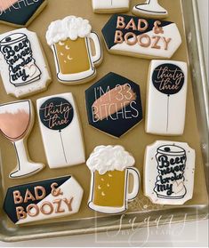 decorated cookies in the shape of beer mugs and glasses are displayed on a tray