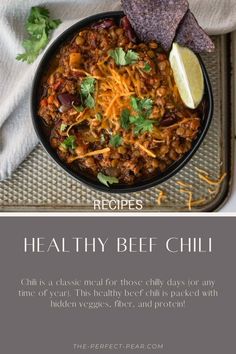 a bowl filled with chili, cheese and tortilla chips on top of a tray